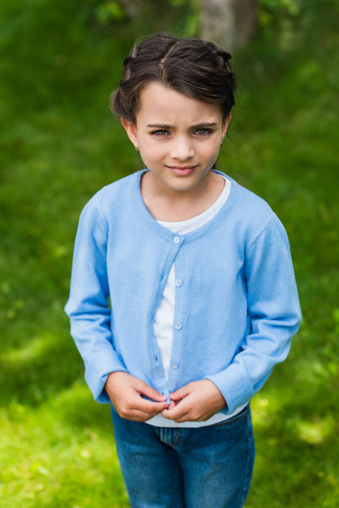 upset ukrainian child looking at camera outdoors - Foto, Imagen