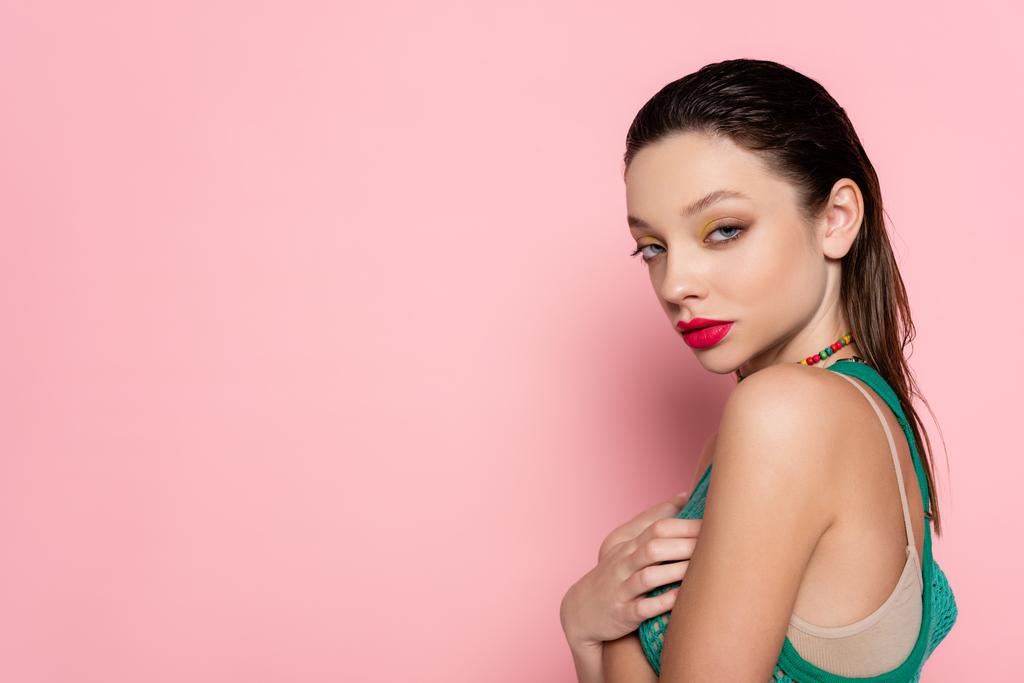 young brunette woman with bright makeup posing on pink background - Fotó, kép