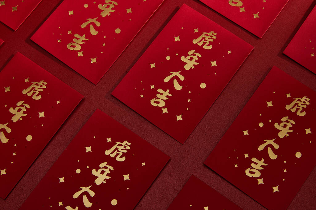 Un primer plano chino sobres rojos para el dinero aislado sobre un fondo rojo oscuro - Foto, Imagen