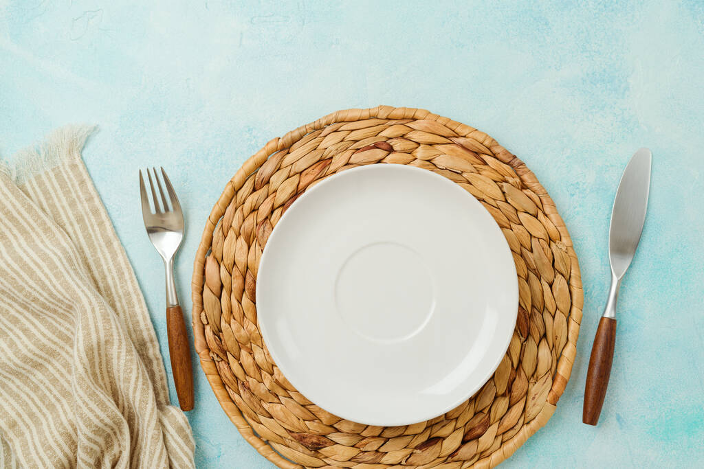 Modern table setting with empty plate, tablecloth and silverware. Mock up background for display. Top view, flat lay - Photo, Image