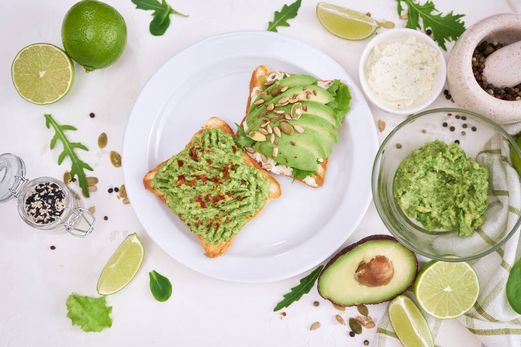 avocado and cream cheese toasts on a plate and ingredients. - Foto, immagini