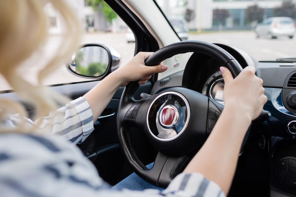 Cropped view of blonde driver holding steering wheel of car  - Fotoğraf, Görsel