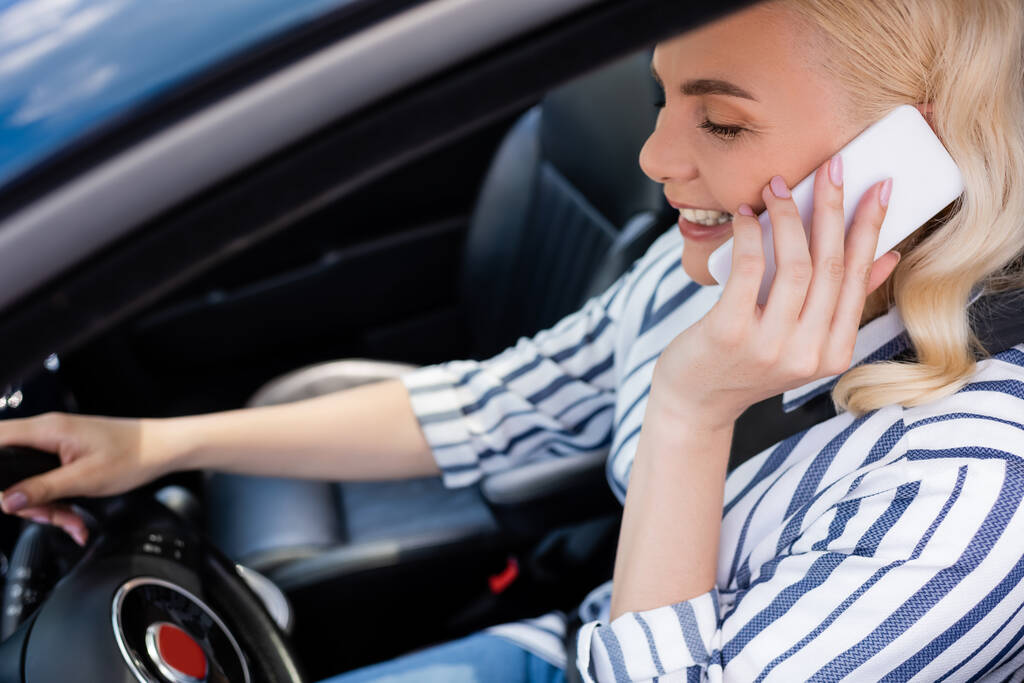 Smiling woman talking on mobile phone during driving course in auto  - Foto, Imagem