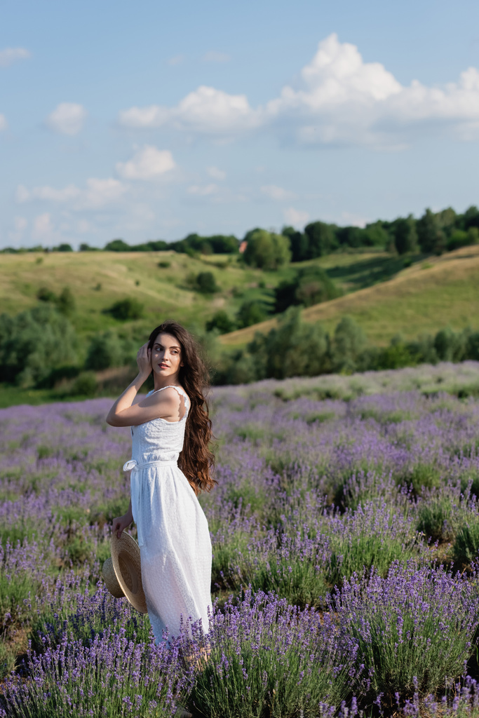pretty woman in white dress looking away in field with blossoming lavender - Photo, Image