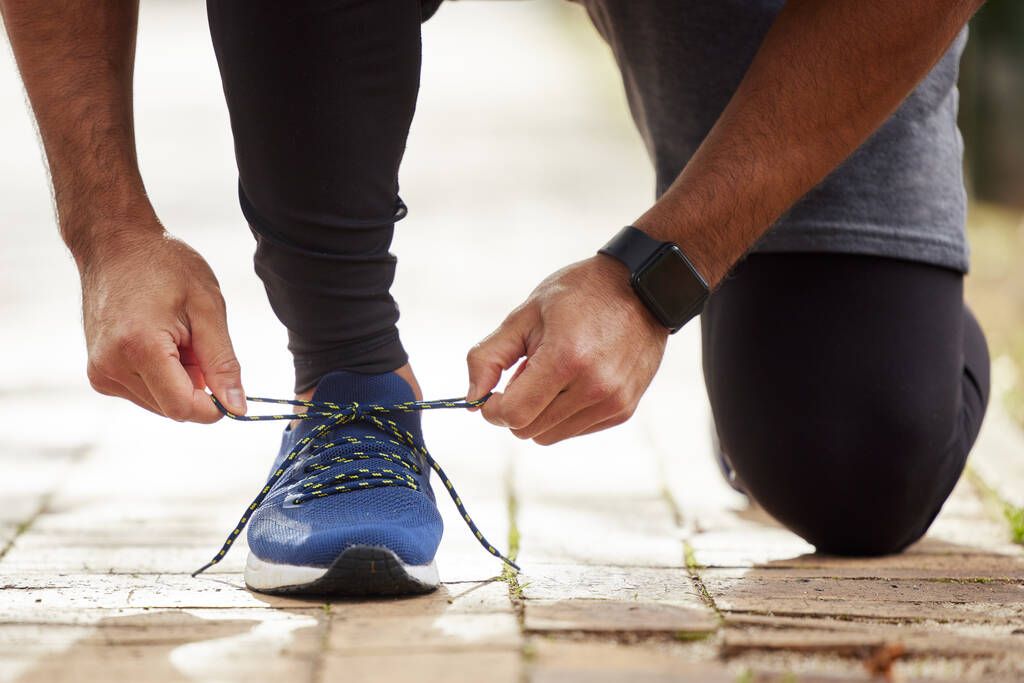 Come on, lets go run. Closeup shot of an unrecognisable man tying his shoelaces while exercising outdoors - Foto, immagini