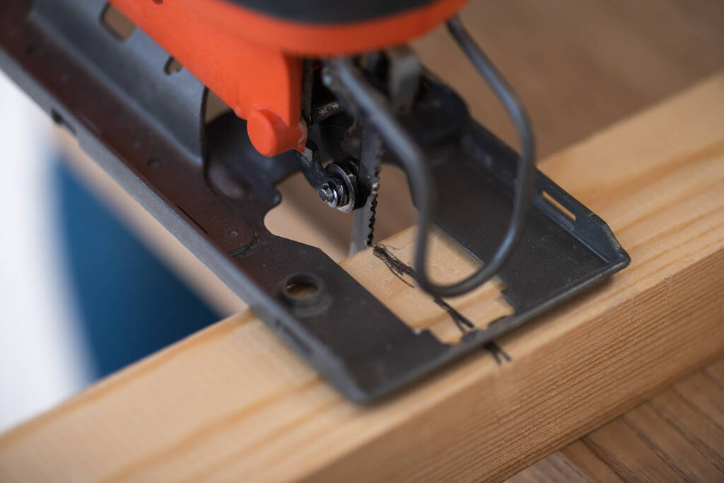 Close up view of electric jigsaw machine and wooden plank  - Zdjęcie, obraz