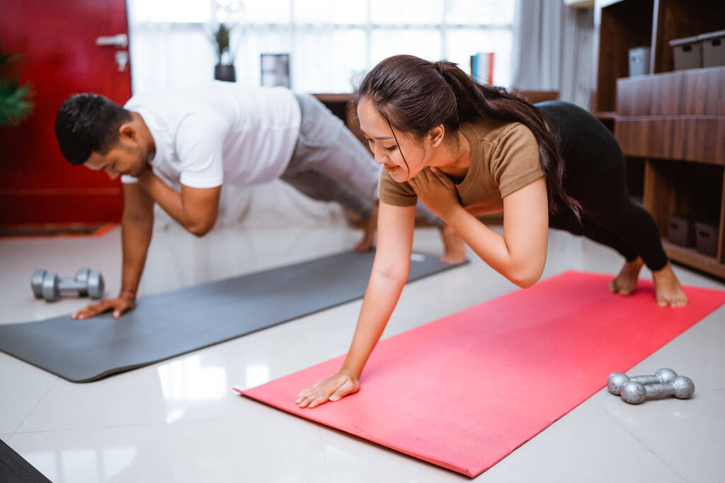Asian fitness couple planking together. man and woman exercising at home - Foto, imagen