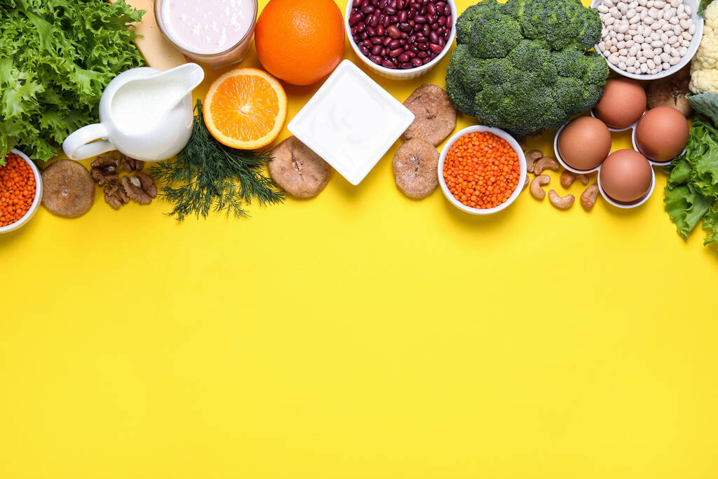 Food high in calcium. Flat lay composition with different products on yellow background, space for text - Photo, image