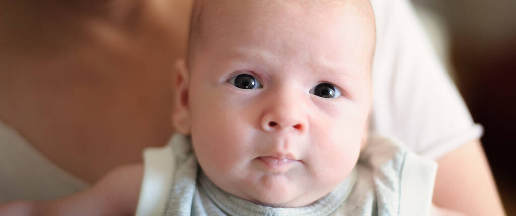 Close-up detail portret van schattige kleine vredige pasgeboren baby jongen kind gezicht met mooie open ogen. Liefde en emotie van het gezin - Foto, afbeelding