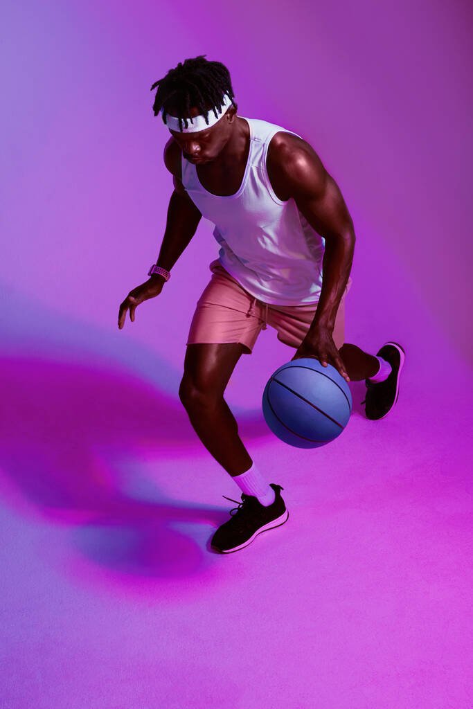I play the game and I play it well. Purple filtered shot of a sporty young man playing basketball - Fotografie, Obrázek