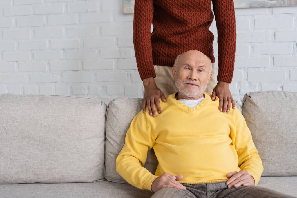African american man hugging granddad on couch at home  - Valokuva, kuva