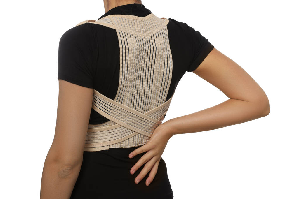 Closeup view of woman with orthopedic corset on white background - Foto, imagen