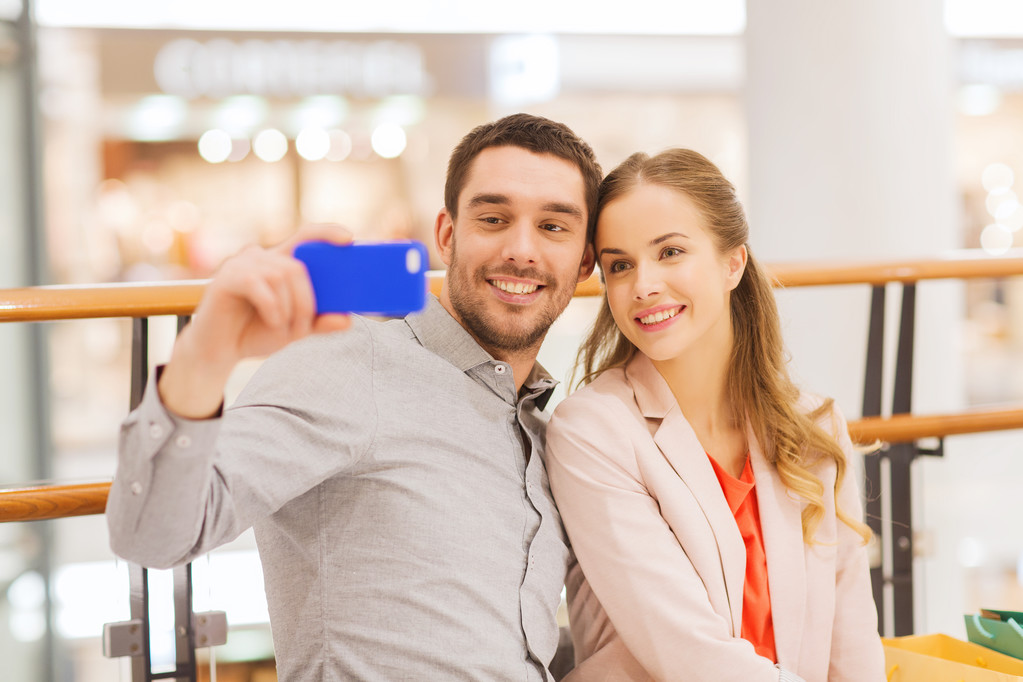 モールで selfie を取ってスマート フォンで幸せなカップル - 写真・画像