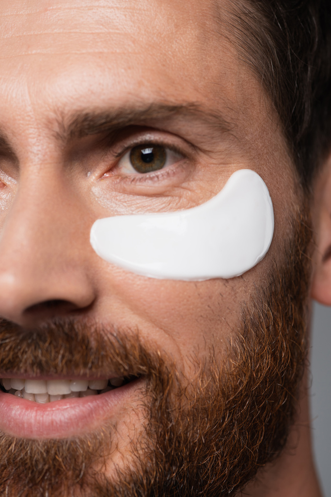 close up view of happy bearded man with moisturizing eye patch  - Fotó, kép