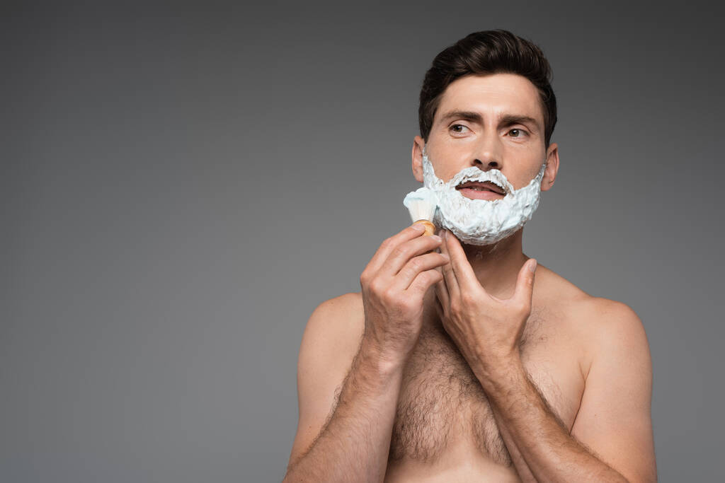 shirless άνθρωπος εφαρμογή λευκό αφρό ξυρίσματος στο πρόσωπο σε γκρι - Φωτογραφία, εικόνα