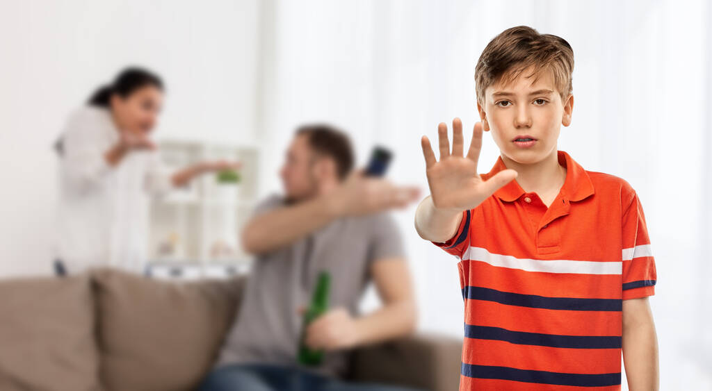 эмоциональное насилие, семейные проблемы и концепция насилия - мальчик в футболке с красным поло показывает остановку жеста над родителями, дерущимися на заднем плане - Фото, изображение