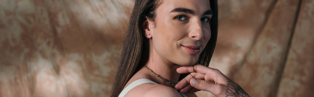 Portrait of smiling brunette queer person on abstract background, banner  - Foto, Imagem