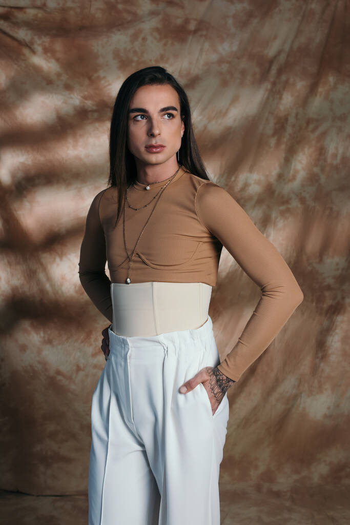 Trendy nonbinary person in corset posing on abstract brown background  - Fotografie, Obrázek