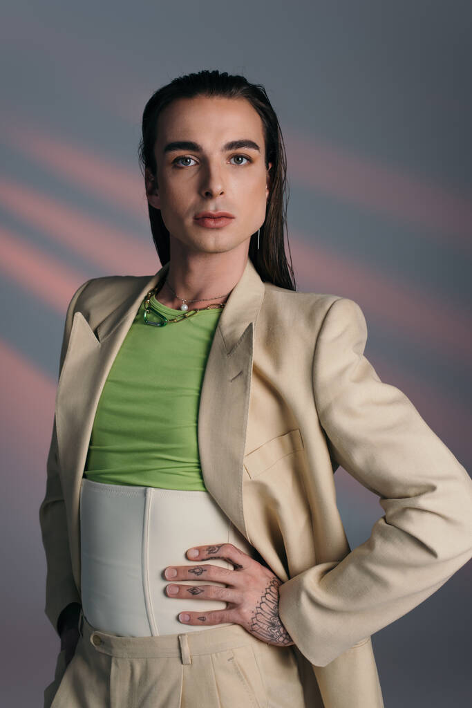 Stylish queer person in suit looking at camera on abstract background  - Foto, immagini