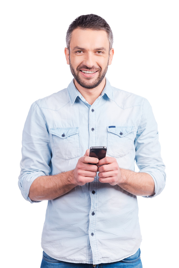 Мужчина в повседневной одежде держит смартфон
 - Фото, изображение