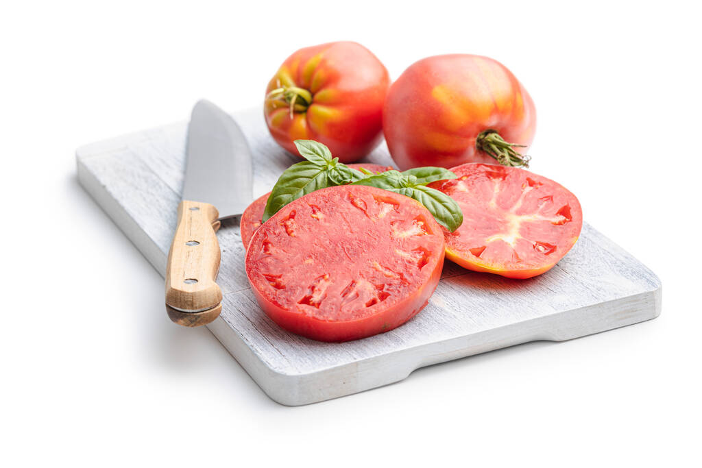 Sliced bull heart tomatoes on cutting board isolated on a white background. - Foto, immagini
