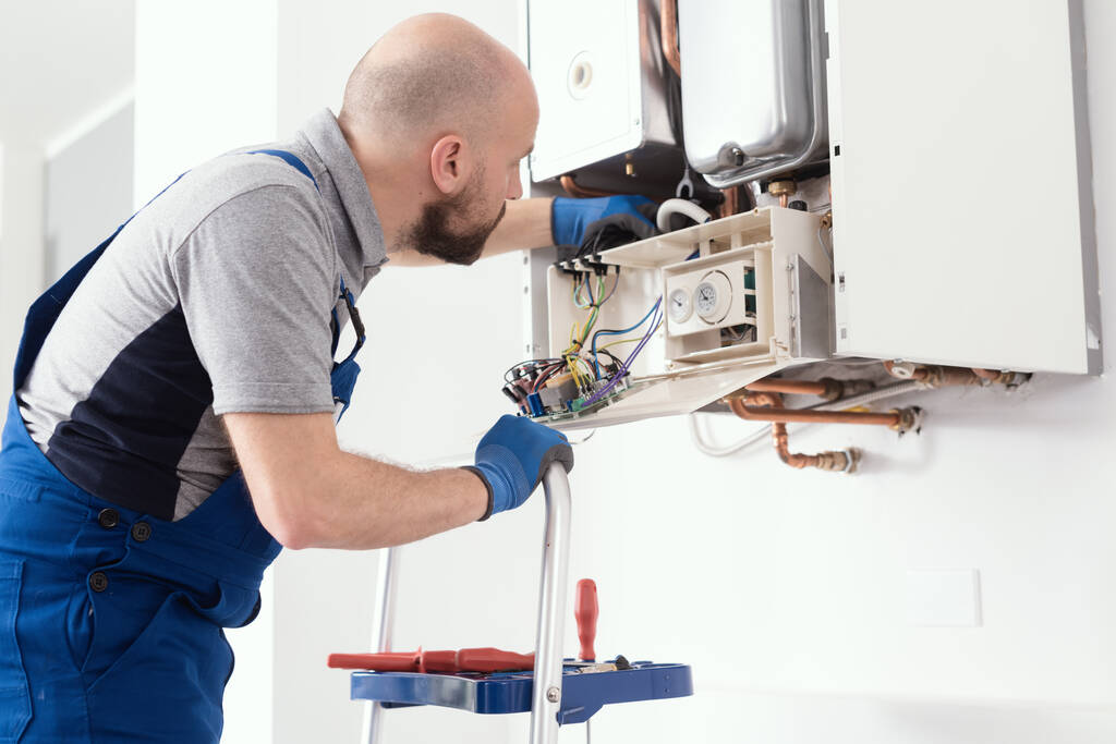 Professional boiler service: qualified technician checking a natural gas boiler at home - Foto, Bild