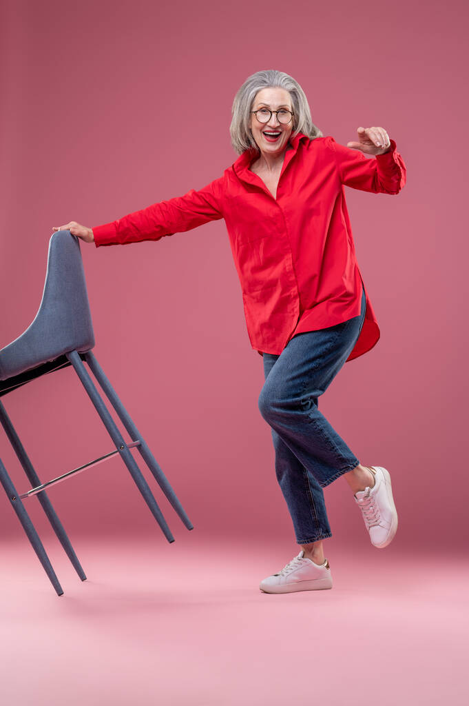 Active woman. Active mature woman in a red shirt in a studio - Photo, image