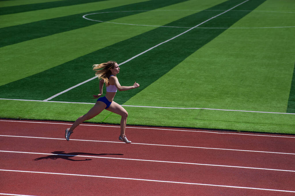 młoda kaukaska kobieta jest zaangażowany w jogging na stadionie na świeżym powietrzu - Zdjęcie, obraz