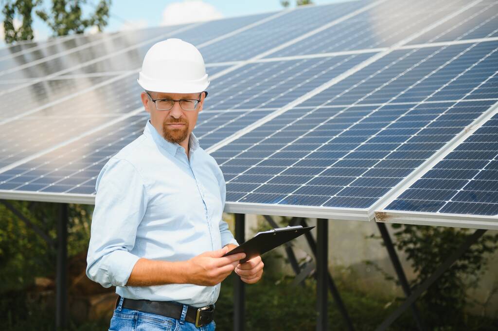 Solar energy. Young business man near the solar panels to power plants - Foto, Bild