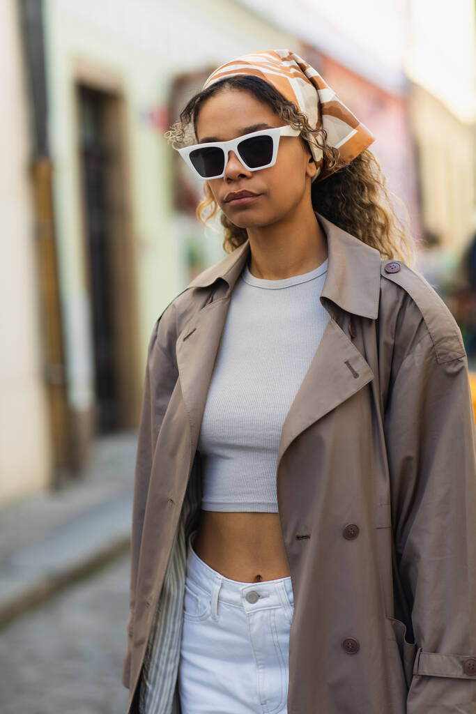 Африканская американка в платке и стильных солнцезащитных очках на улице в Праге  - Фото, изображение