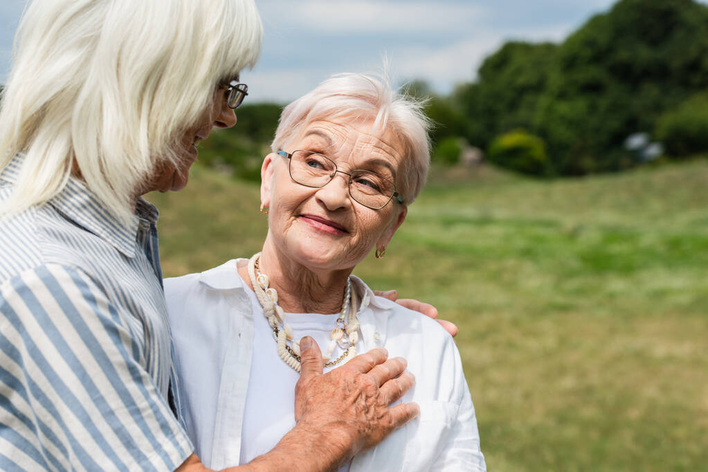 happy senior man in glasses putting hand on chest of smiling wife  - Photo, image