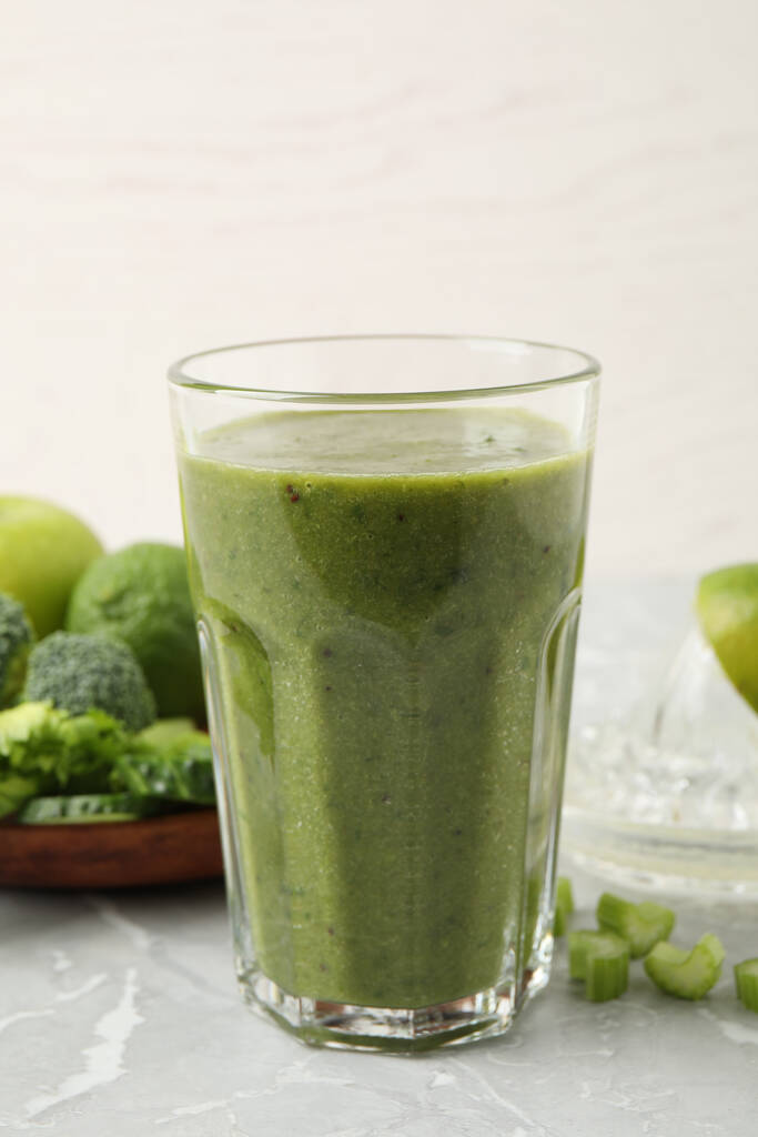 Delicious fresh green juice on grey marble table - Fotó, kép