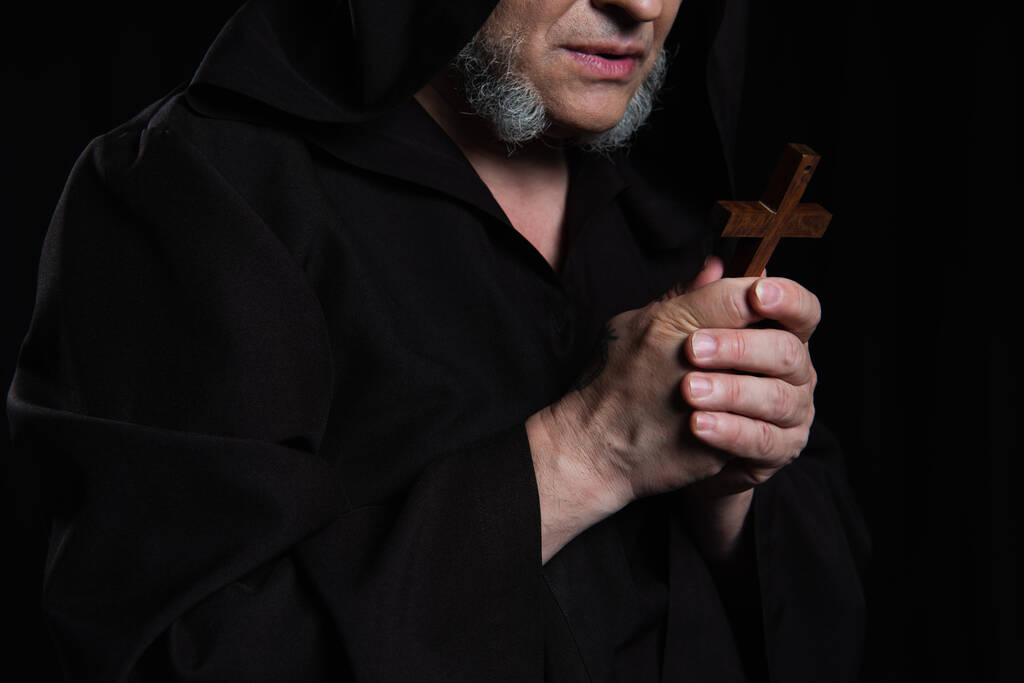vista parcial del monje mayor con crucifijo de madera aislado en negro - Foto, imagen