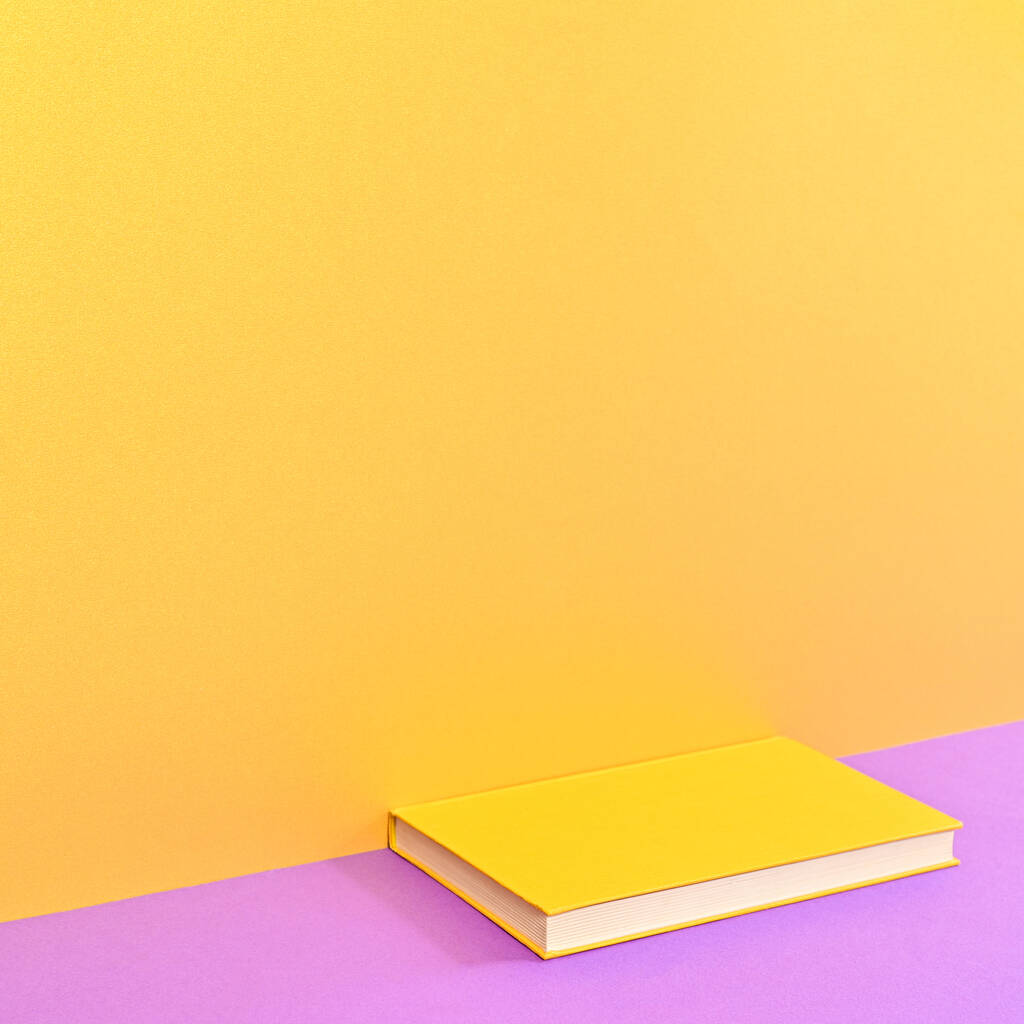 Creative background with copy space and hardcover book on golden purple background. Flat lay minimal concept - Foto, Imagem