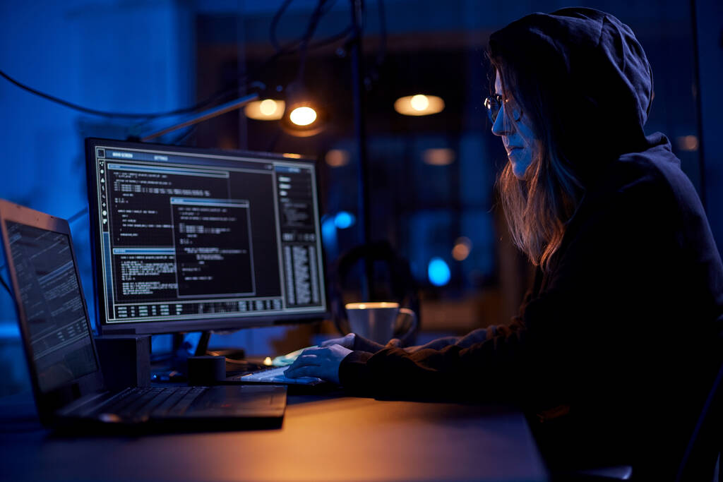 cybercrime, hacking and technology concept - γυναίκα χάκερ σε σκοτεινό δωμάτιο γράφοντας κώδικα ή χρησιμοποιώντας πρόγραμμα ιών υπολογιστών για κυβερνοεπίθεση - Φωτογραφία, εικόνα