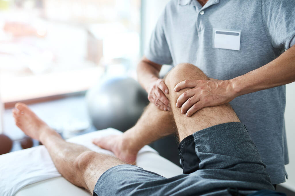 Knees require a delicate touch. an unrecognizable male physiotherapist treating a patient - Foto, Imagen
