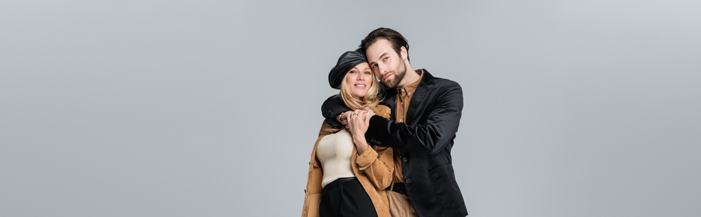 cheerful man hugging happy woman in stylish beret isolated on grey, banner - Fotografie, Obrázek