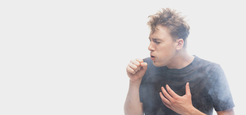 Suffocate in the smoke. Scared young man with stressed emotions isolated over white background with clouds of smoke. Concept of mental health, art, human emotions, challenges, ad - Photo, image