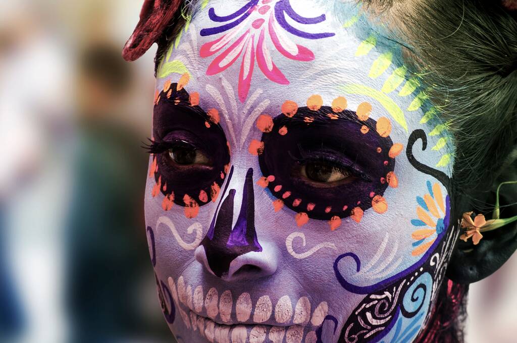 Egy közelkép egy nőről színes koponyasminkkel, aki a halál napját ünnepli. - Fotó, kép