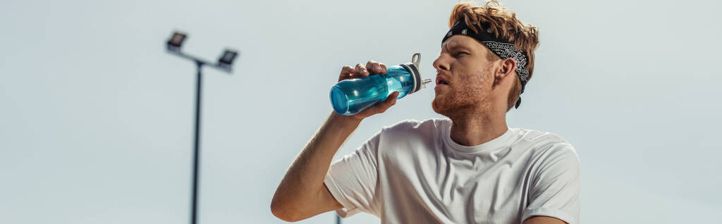 young sportsman drinking refreshing water from sports bottle outdoors, banner - Foto, Imagem