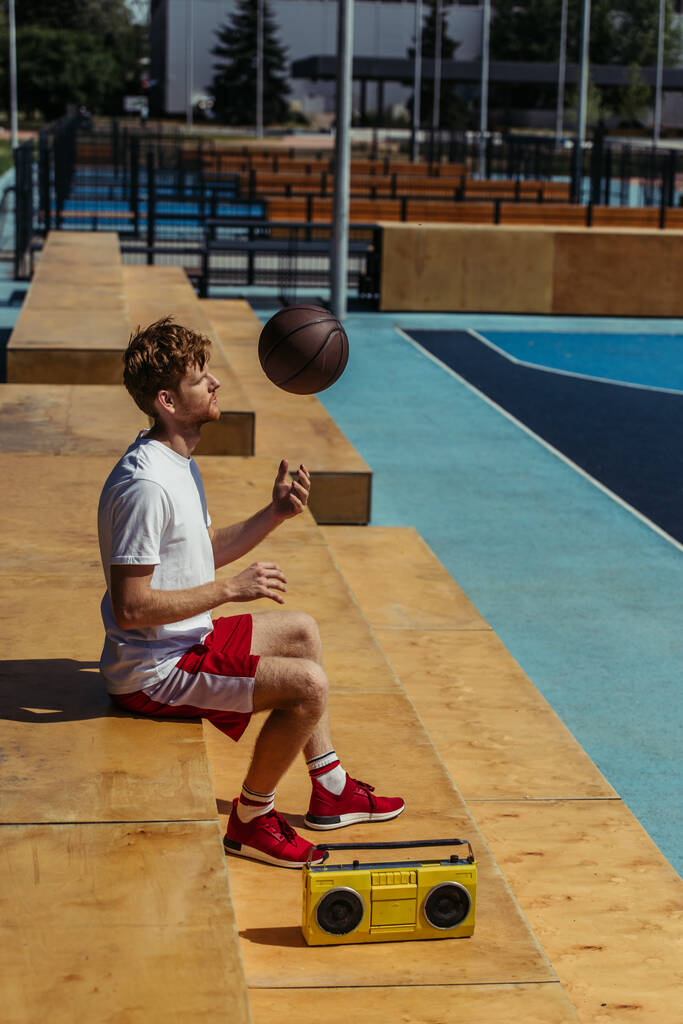 вид збоку спортсмен грає з м'ячем, сидячи на стадіоні поблизу рекордного гравця
 - Фото, зображення
