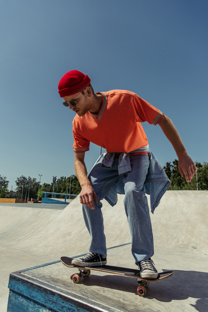 young and stylish skater jumping from ramp in skate park - 写真・画像