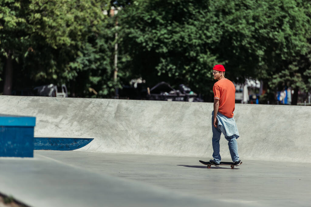 full length of man in stylish outfit training in city skate park - Photo, Image