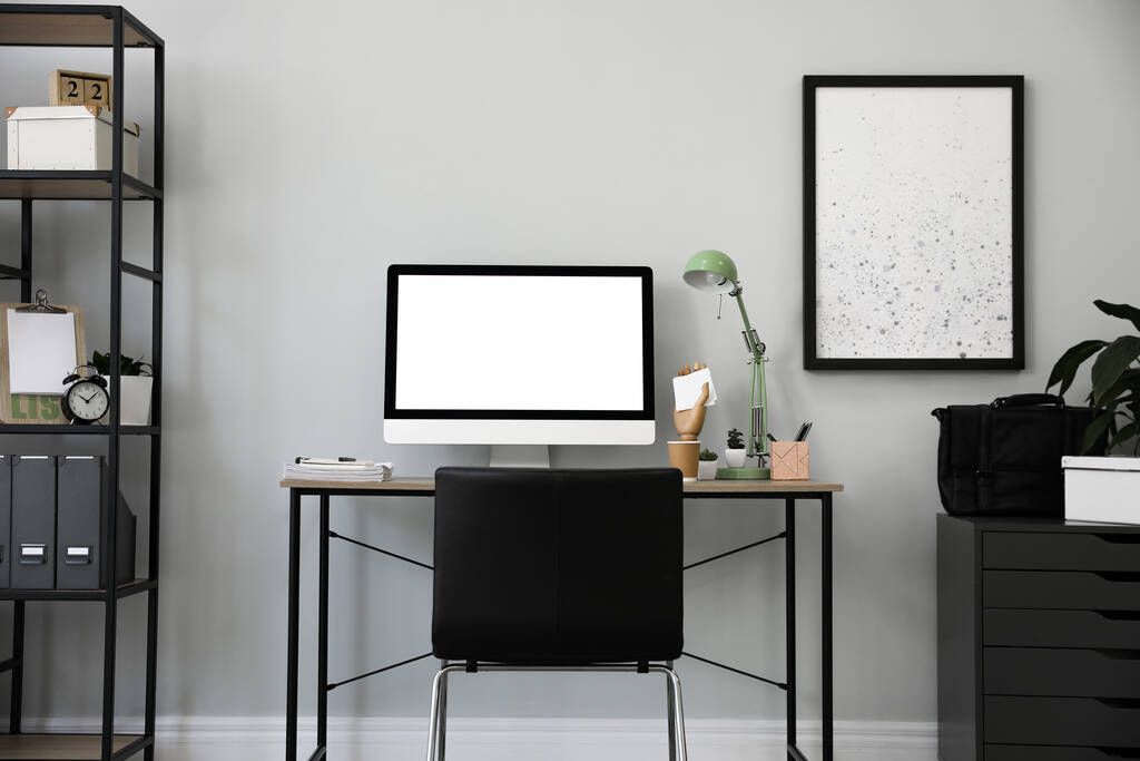Bequemer Bürostuhl neben Schreibtisch mit modernem Computer drinnen - Foto, Bild