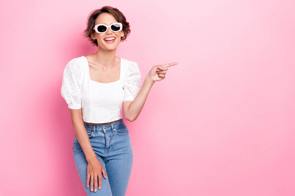 Photo of adorable gorgeous pretty nice girl dressed white top glasses jeans indicating empty space isolated on pink color background. - Foto, immagini