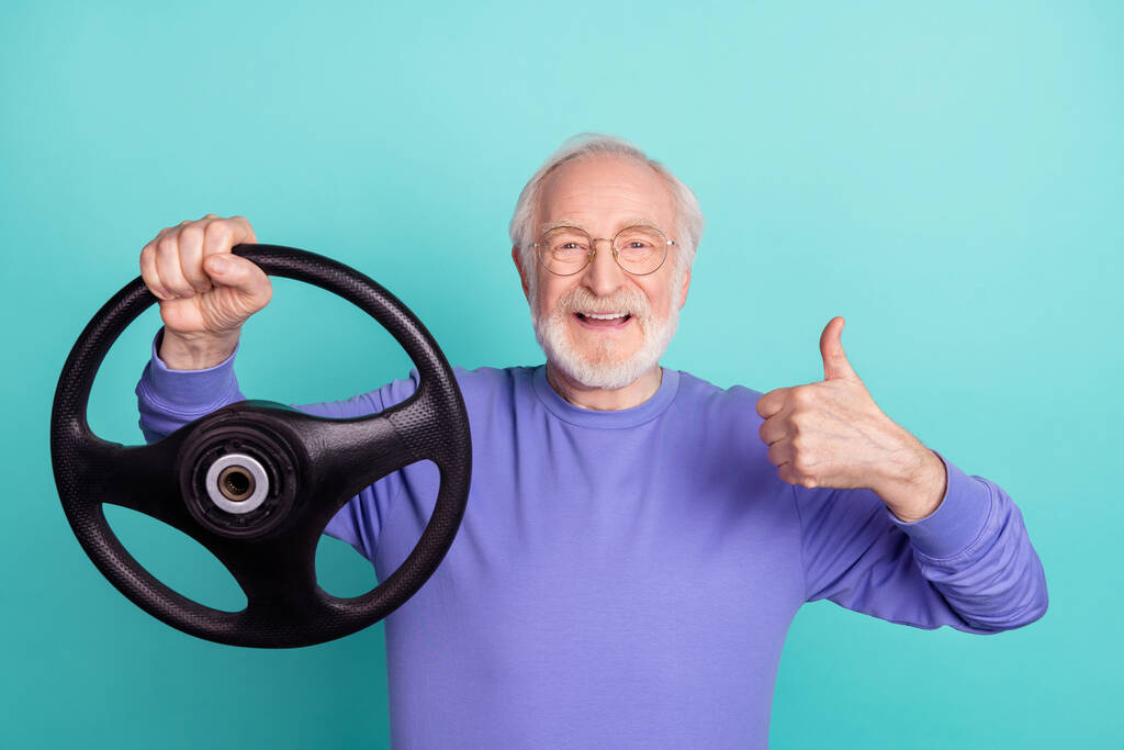 Photo of handsome aged man arm hold wheel demonstrate thumb up feedback isolated on turquoise color background. - Foto, immagini