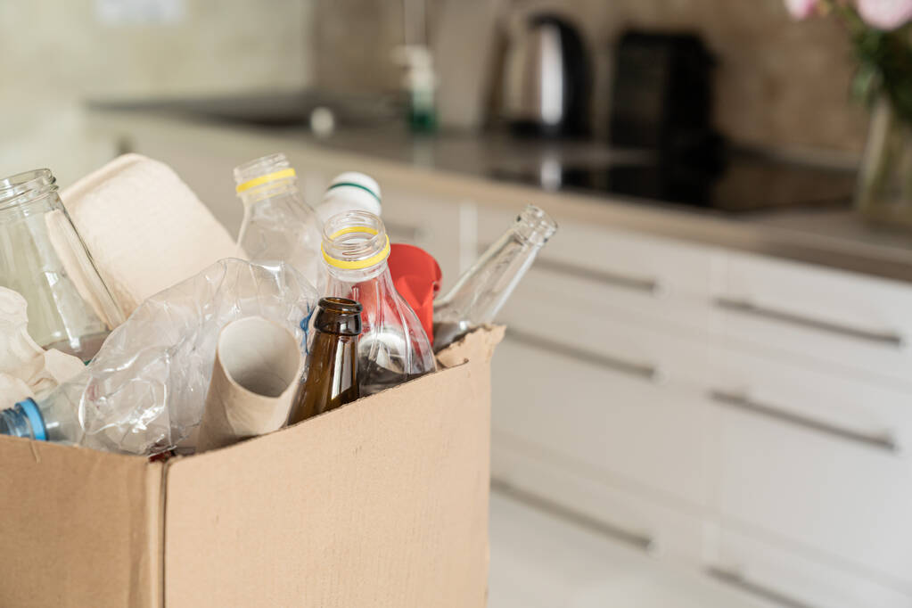 Recycling concept - box of recycling materials in kitchen background. High quality photo - Foto, afbeelding