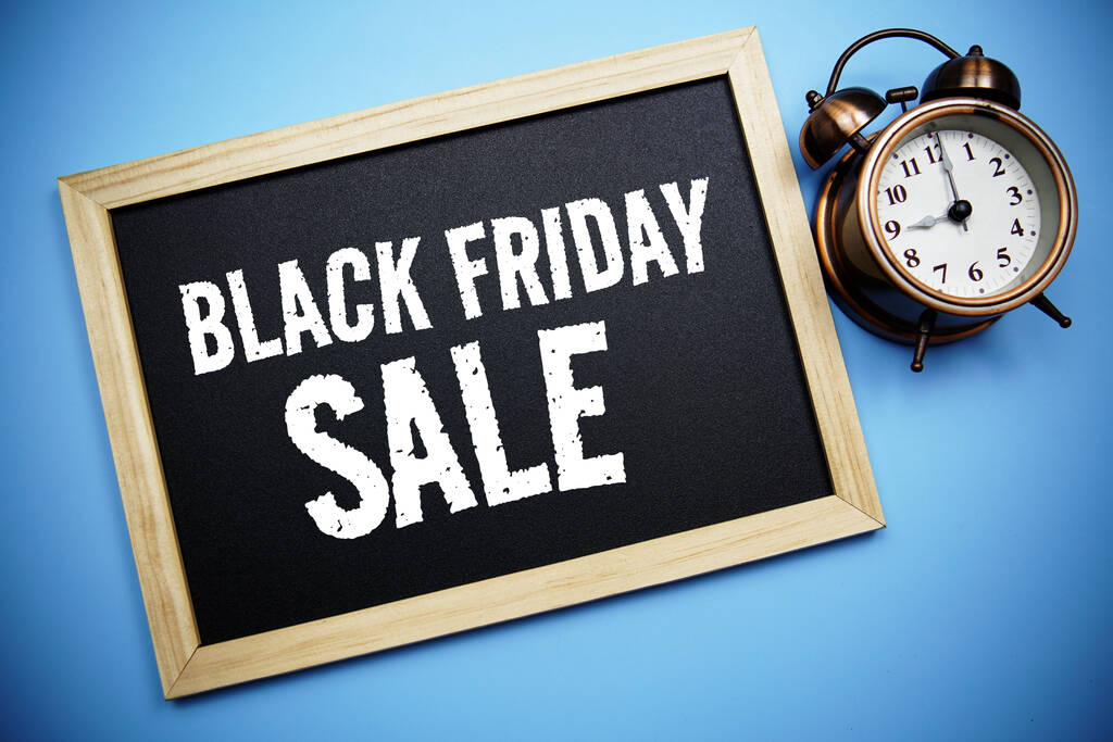 Black Friday Sale text message on Blackboard and alarm clock on blue background - Foto, afbeelding