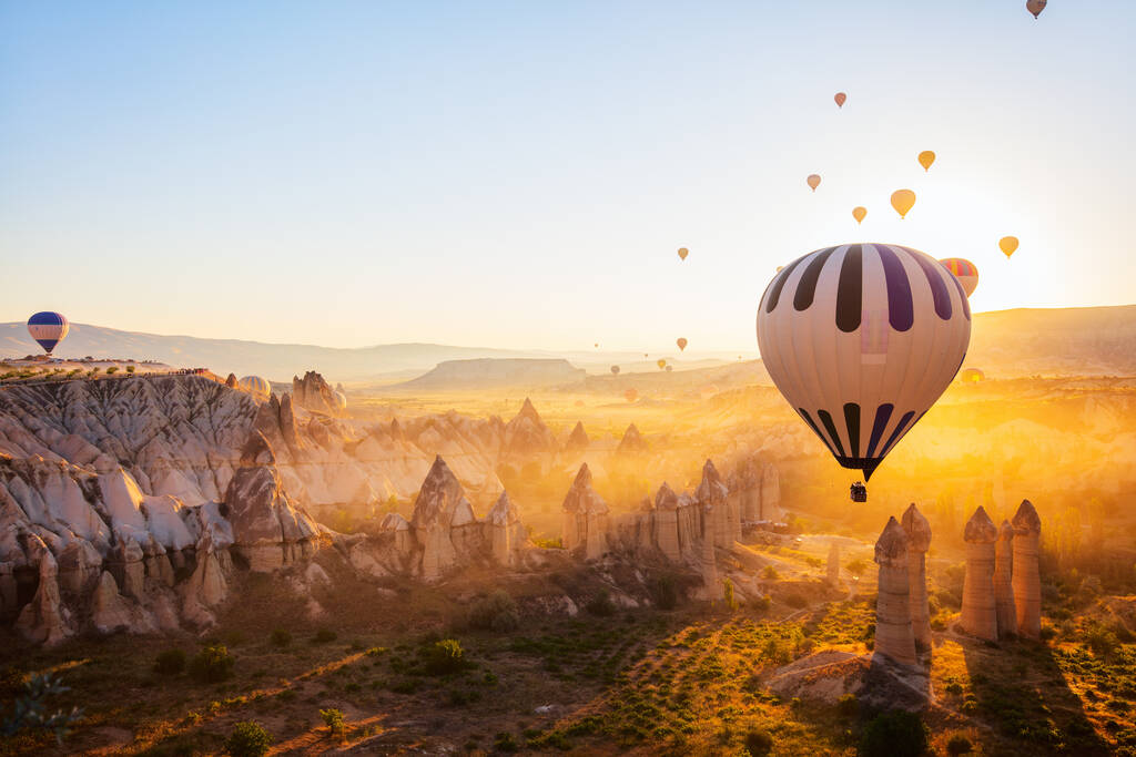 Gorgeous sunrise scenery of hot air balloons flying over Love valley with rock formations and fairy chimneys in Cappadocia Turkey - Fotografie, Obrázek