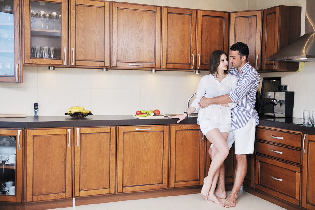 Ευτυχισμένο νεαρό ζευγάρι διασκεδάζουν στη σύγχρονη κουζίνα - Φωτογραφία, εικόνα